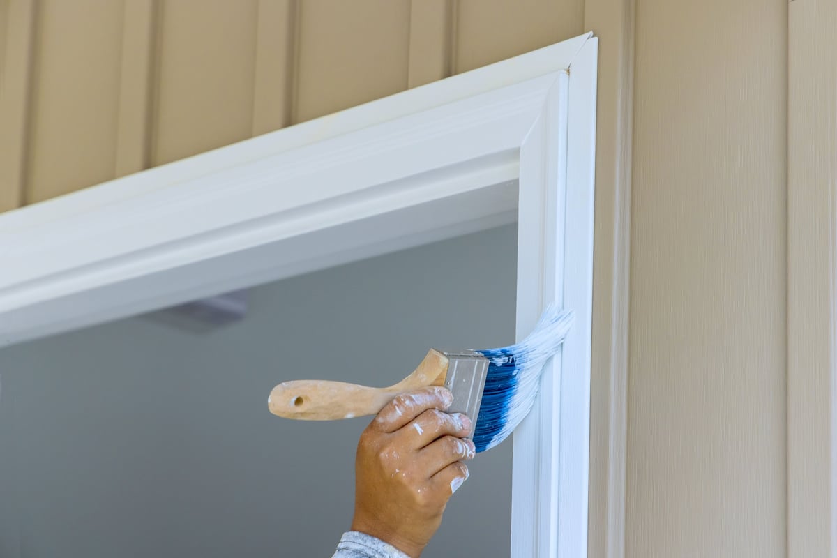 Door and surround being painted, typical of trim and entry-door finish work