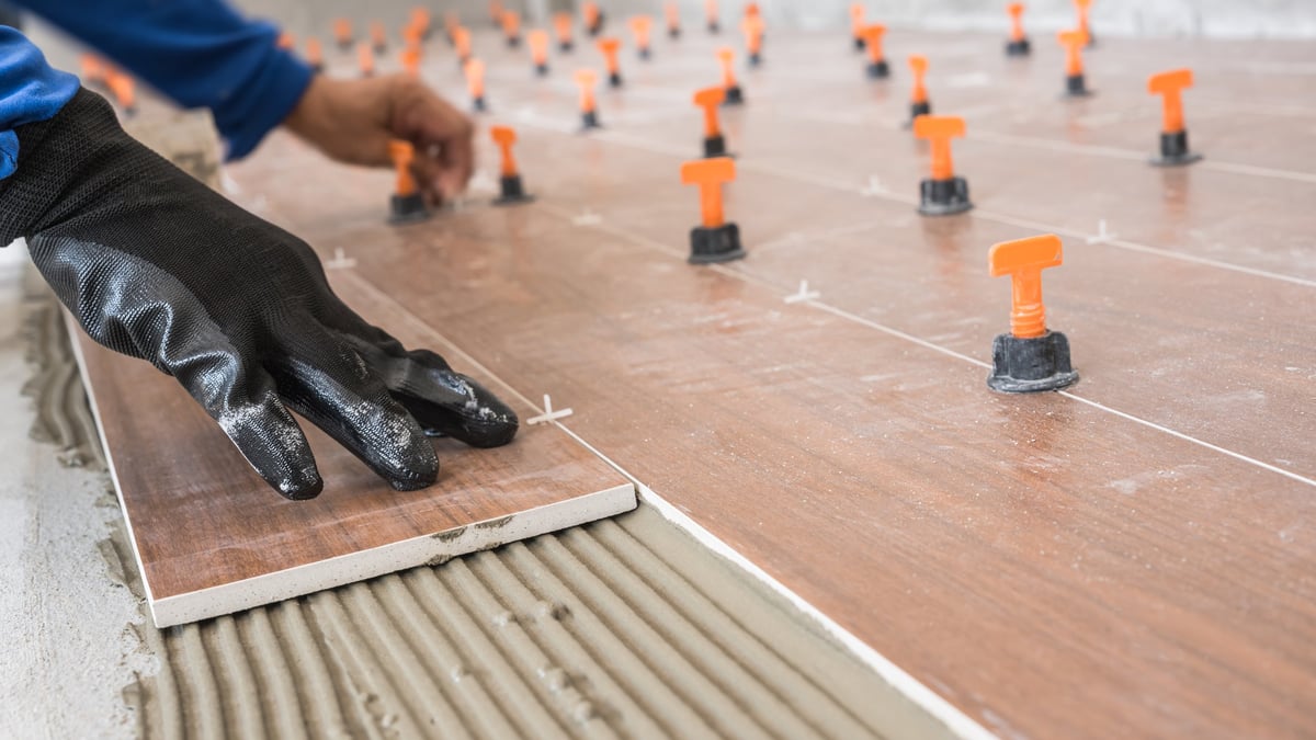 Craftsman setting tile and finish surface during an interior repair