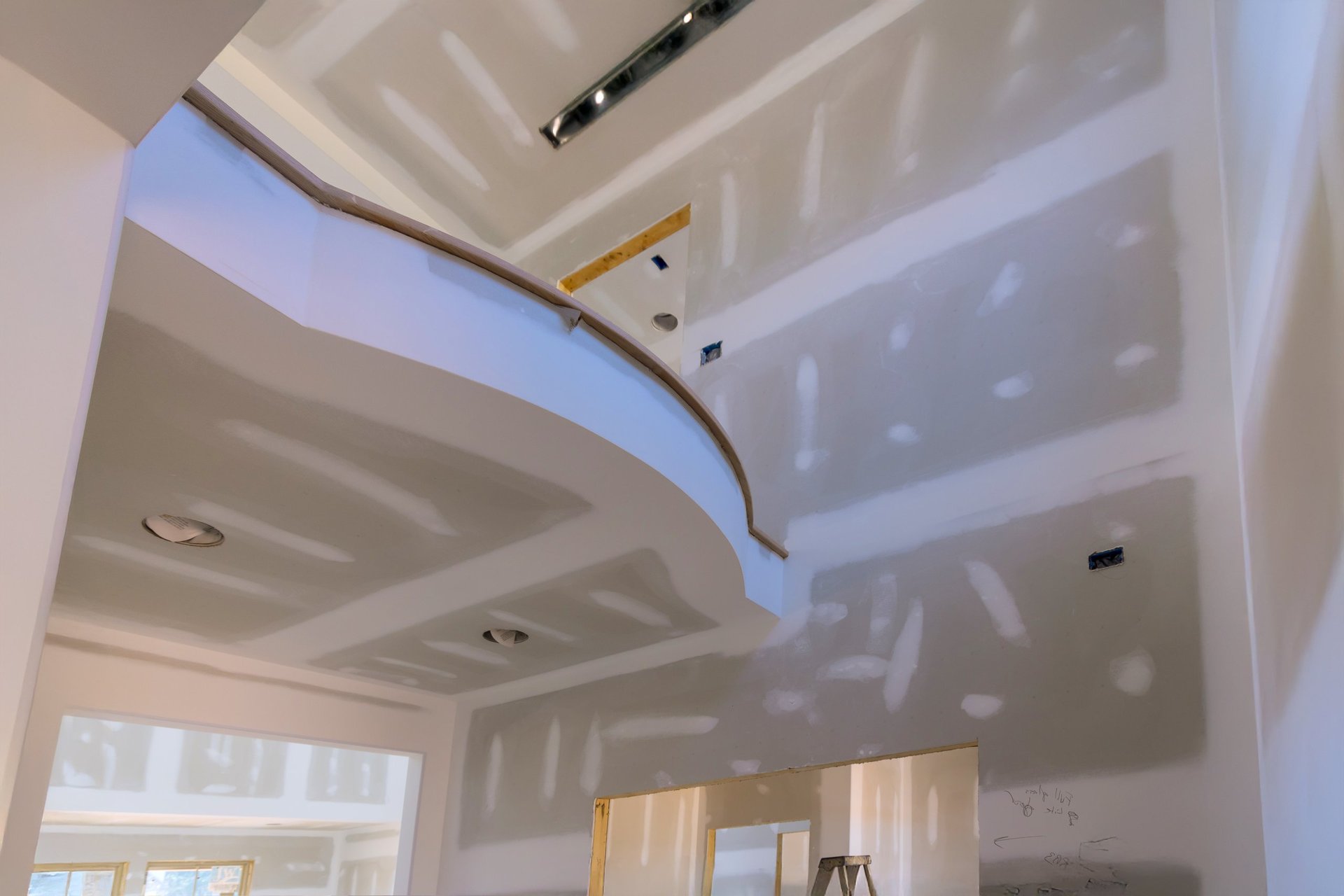 Craftsmen preparing interior walls and finish surfaces in a large home