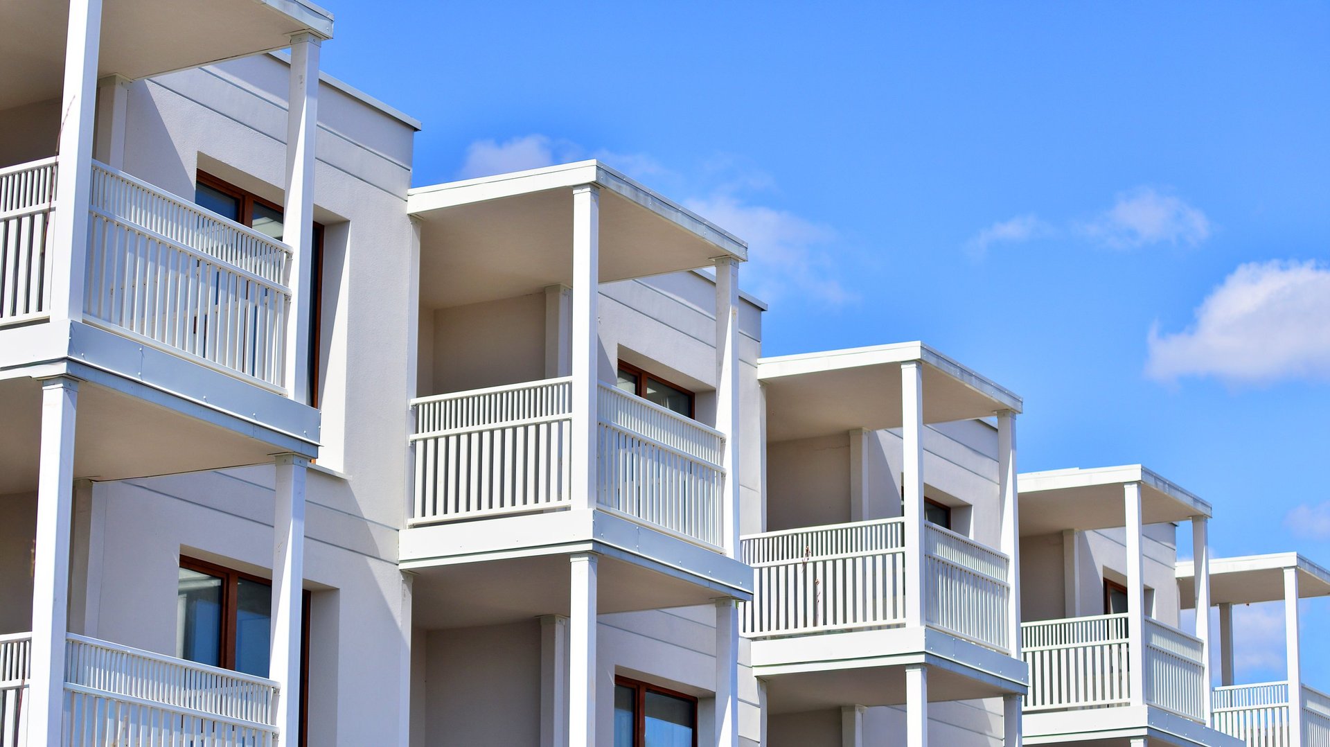 Exterior of a multi-story residential building with maintained windows and balconies