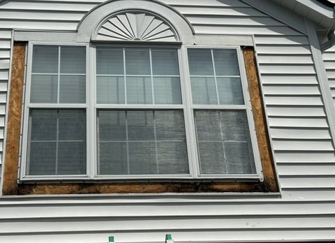 Darby Park window during restoration, with existing trim removed and the underlying material exposed ahead of remediation and PVC replacement.
